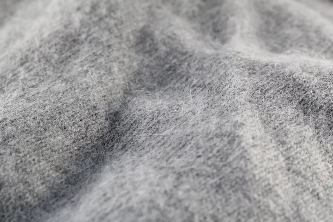 Close-up of a soft grey knit, long fine hairs standing off the surface as a halo.