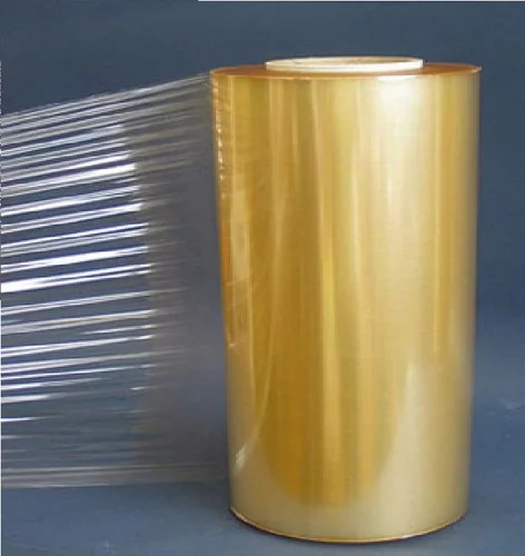 A roll of clear PVC film with a transparent sheet drawn off it to the left, against a neutral grey ground.